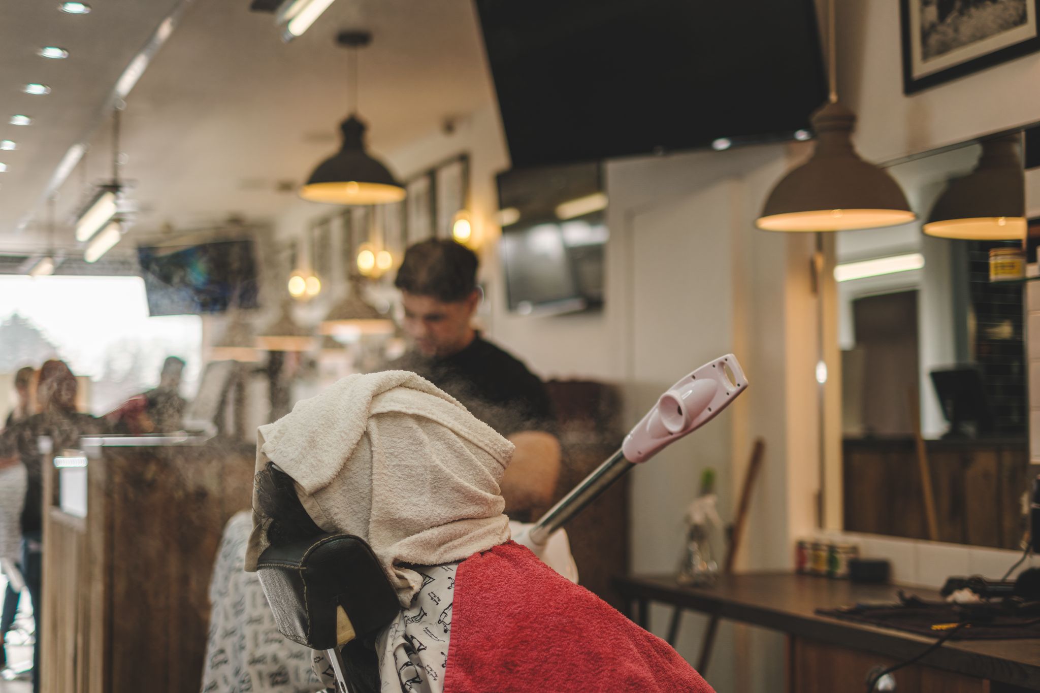 Man with a hot towel at Seven Hair and Body Barbers in Peterborough